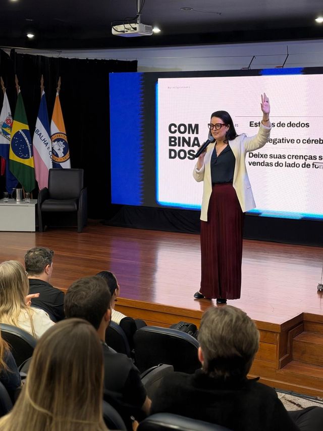 Grazi Guaspari conduzindo um treinamento de vendas em auditório
